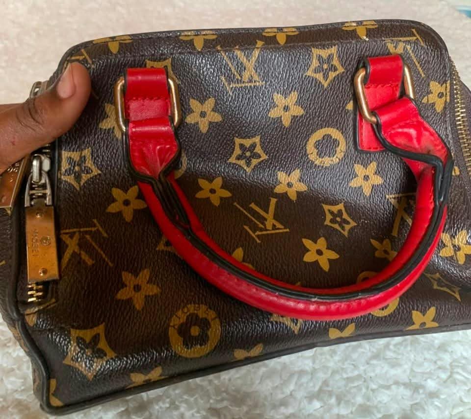 Brown print barrel bag with red handles