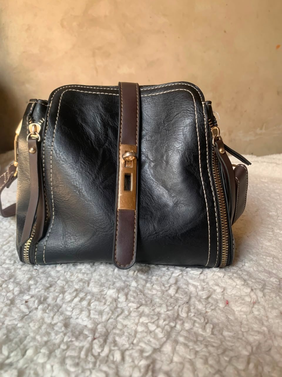 Black mini shoulder bag with tan clasp