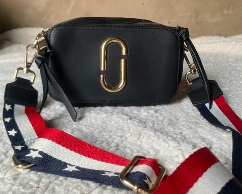 Black camera crossbody with striped strap